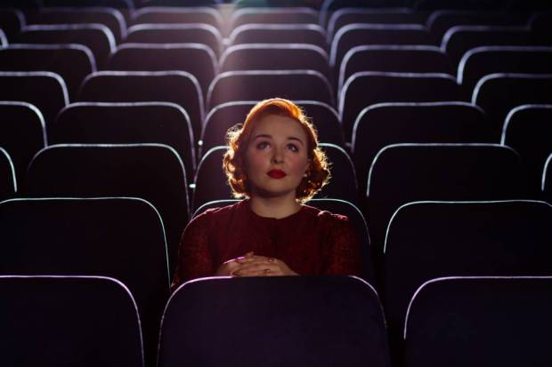 Redhead woman sitting alone in cinema